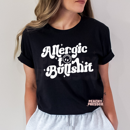 Black unisex t-shirt featuring a white distressed "Allergic to Bullshit" retro graphic with smiley face. Funny sarcastic graphic tee for casual everyday wear.