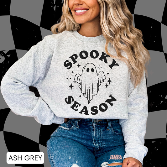 Woman wearing an ash grey Spooky Season ghost crewneck sweatshirt with a simple ghost Halloween design.