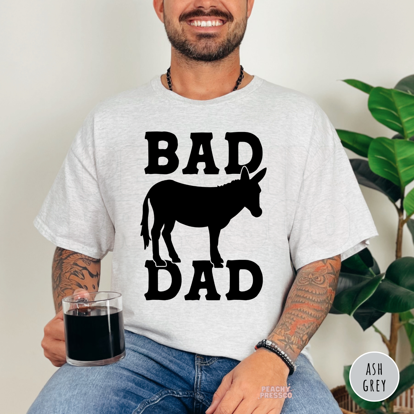 ash grey shirt with a humorous "Bad Ass Dad" donkey silhouette graphic in bold western typography.