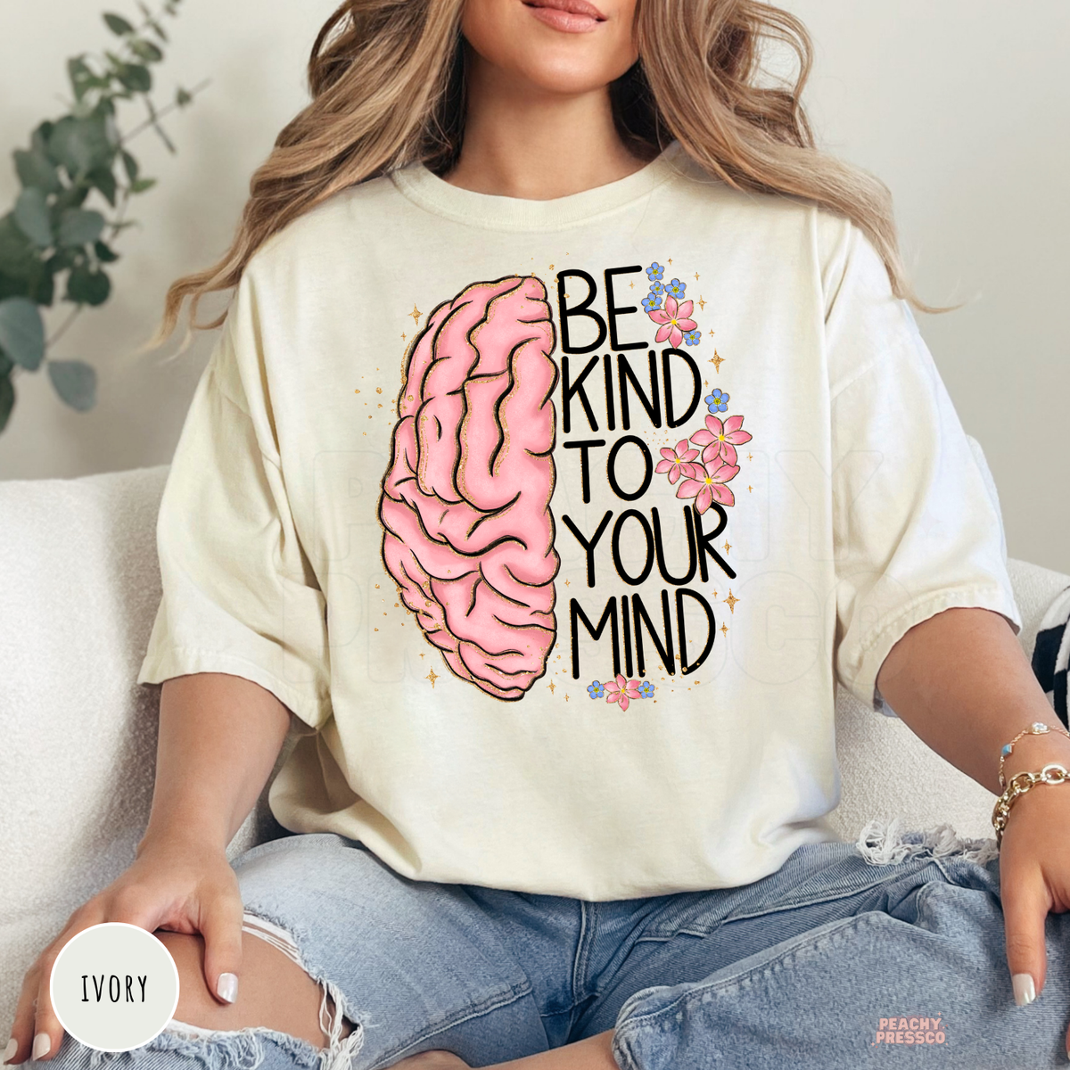 Ivory Comfort Colors t-shirt with a pink brain illustration, floral accents, and the inspirational "Be Kind to Your Mind" graphic in a soft vintage style.
