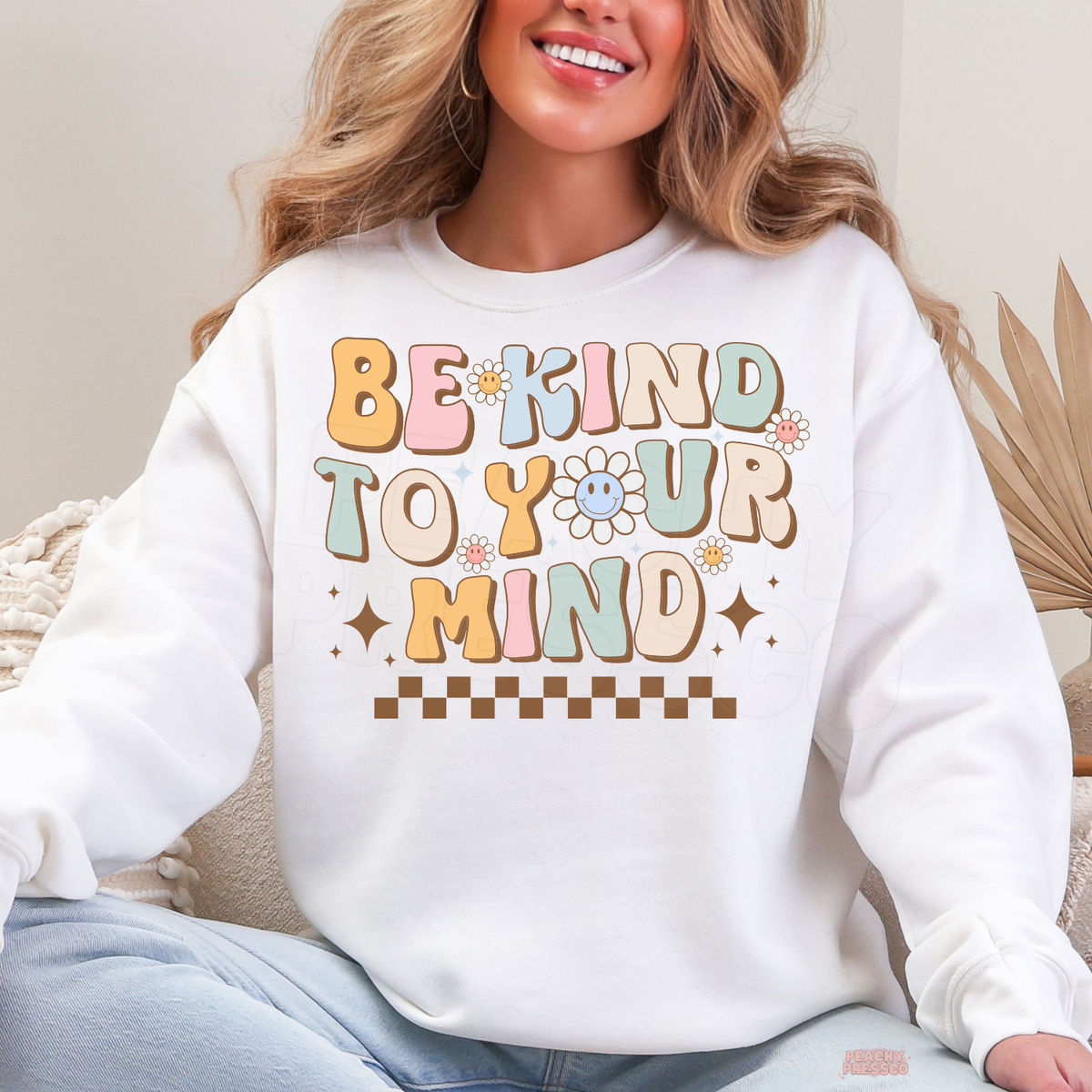 White Be Kind to Your Mind sweatshirt with colourful retro lettering, happy smiley face flowers, sparkling stars and a positive mental health message.