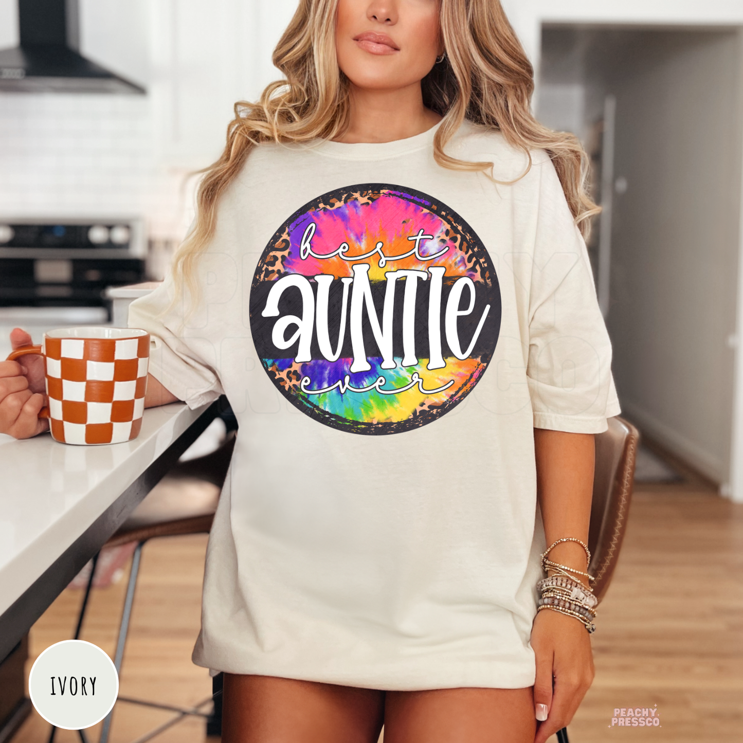 Ivory t-shirt featuring a bright tie-dye and leopard print "Best Auntie Ever" graphic. Cute family-inspired tee for birthdays, baby announcements, or everyday wear.