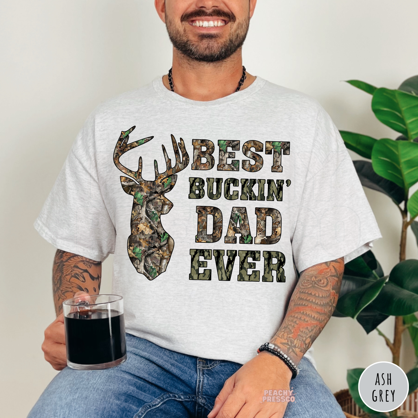 Ash Grey unisex t-shirt featuring a camouflage deer silhouette and Best Buckin' Dad Ever graphic, perfect Father's Day gift for hunting dads.