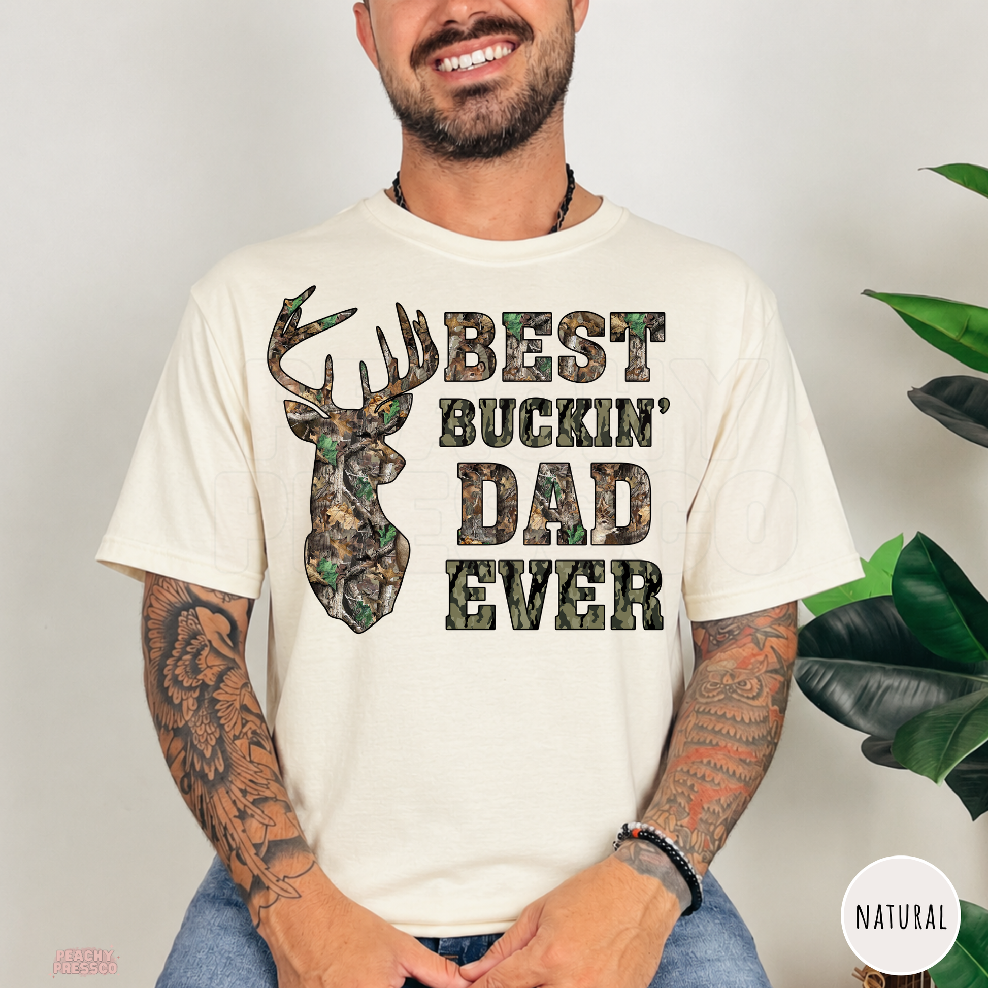 Natural t-shirt featuring a camo deer head and Best Buckin' Dad Ever design, a great Father's Day gift for hunting enthusiasts.