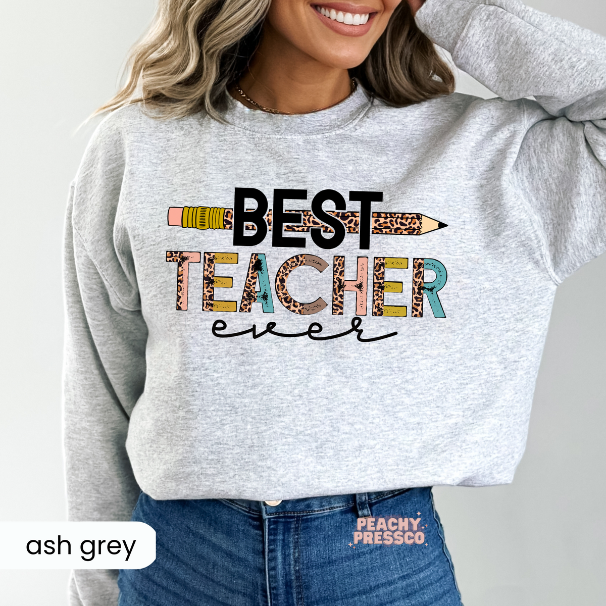 Ash grey teacher sweatshirt featuring a "Best Teacher Ever" design with a leopard print pencil, colorful distressed lettering, and trendy teacher aesthetic.