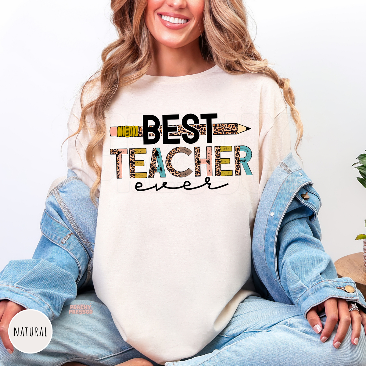 Natural teacher shirt featuring a "Best Teacher Ever" graphic with a leopard print pencil, colorful distressed lettering, and playful classroom-inspired design.