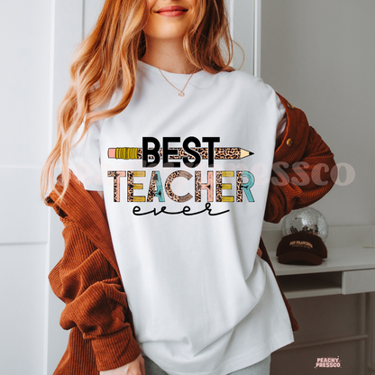 White Comfort Colors teacher t-shirt displaying a "Best Teacher Ever" graphic with a leopard print pencil and colorful distressed lettering for teachers.