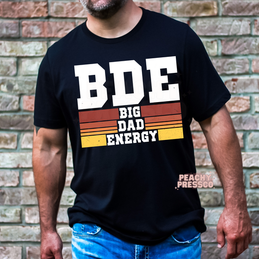 Black unisex t-shirt featuring the Big Dad Energy vintage graphic with distressed lettering and retro sunset stripes, a funny Father's Day gift for dads.