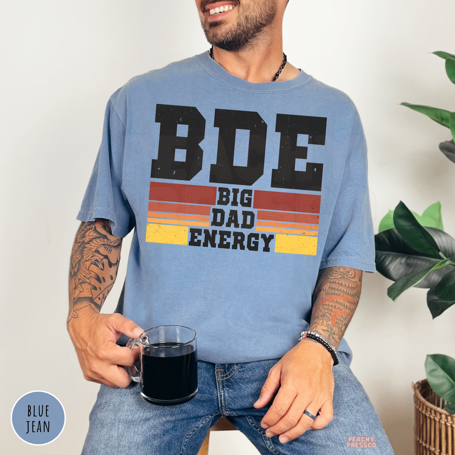 Blue Jean Comfort Colors t-shirt featuring the Big Dad Energy design with distressed lettering and retro sunset stripes, perfect for Father's Day.