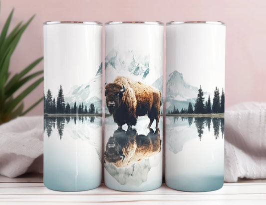 20oz skinny tumbler featuring a majestic bison standing in a mountain lake with scenic forest reflection artwork.