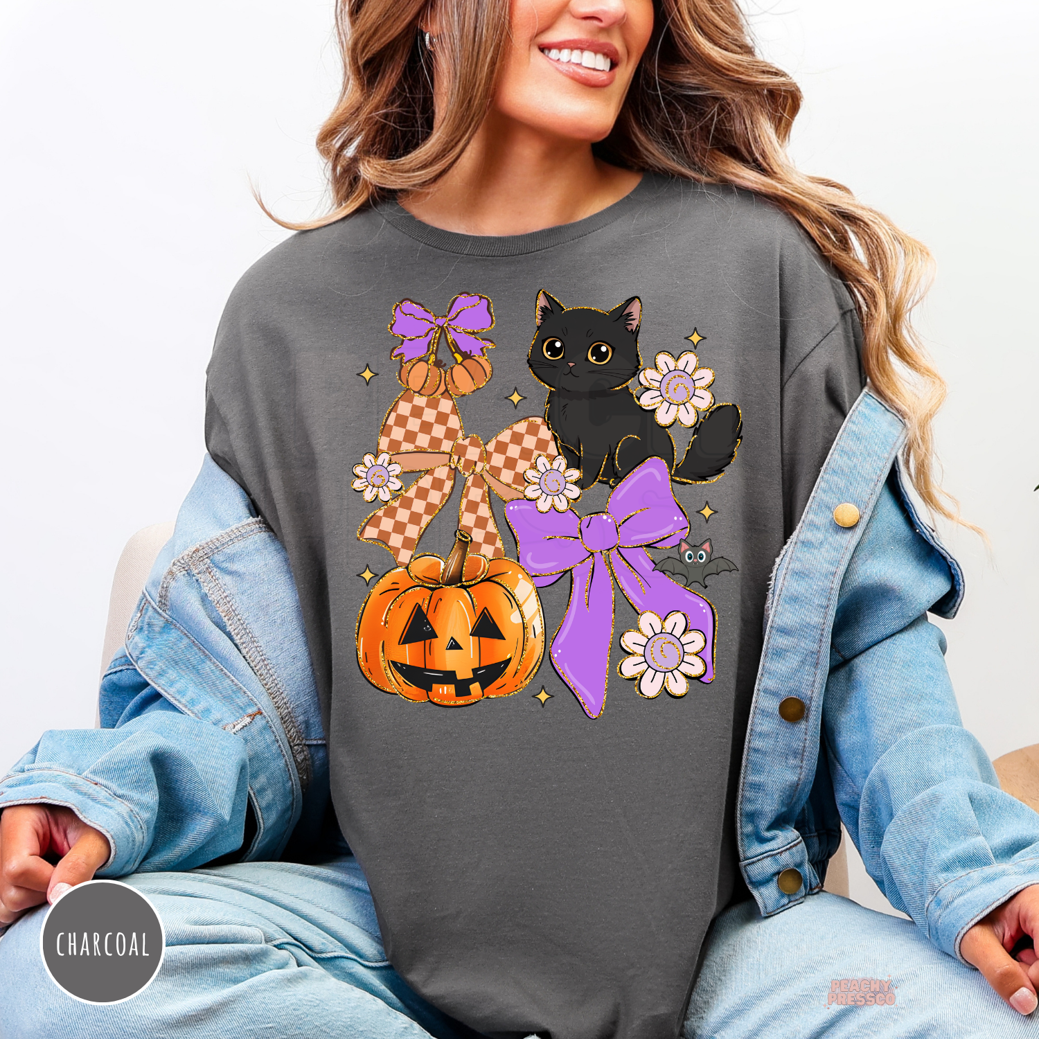 Woman wearing a charcoal crewneck sweatshirt featuring a black cat, pumpkin, purple bows, flowers and bat for Halloween.