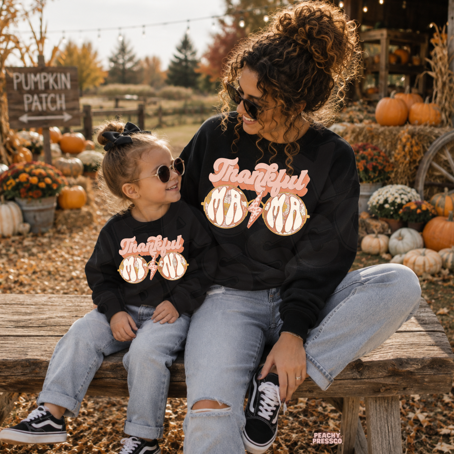 Matching black Thankful Mama crewneck sweatshirts for mother and daughter at a pumpkin patch, perfect for Thanksgiving and fall family photos.