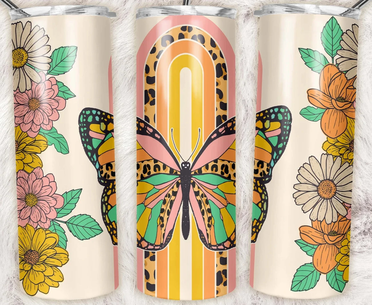 20 oz skinny tumbler featuring a colorful butterfly with retro rainbow stripes, leopard print accents, and floral details. Bright boho tumbler with clear lid and straw.