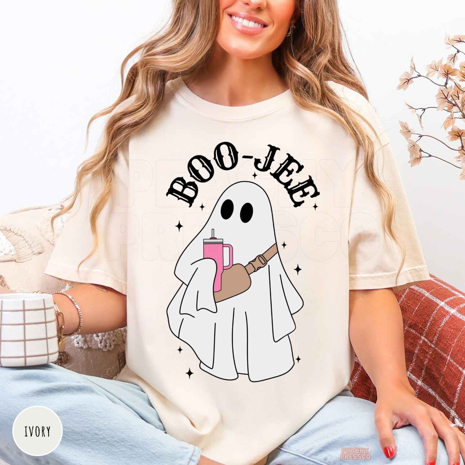 Woman wearing an ivory Comfort Colors Boo-Jee ghost Halloween t-shirt with trendy ghost graphic.