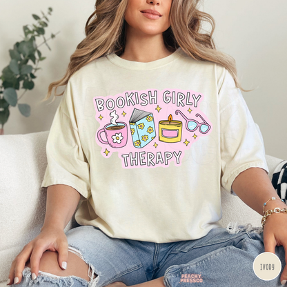 Ivory Comfort Colors tee with Bookish Girly Therapy design featuring a floral book, coffee mug, candle, and glasses.