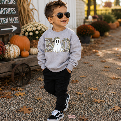 Boy wearing a sport grey Boo camo ghost Halloween sweatshirt with sunglasses in a pumpkin patch fall setting.