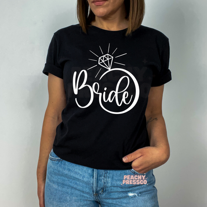 Black t-shirt with a bold white "Bride" engagement ring graphic, creating a modern bridal look for engagement parties, bridal showers, and wedding festivities.