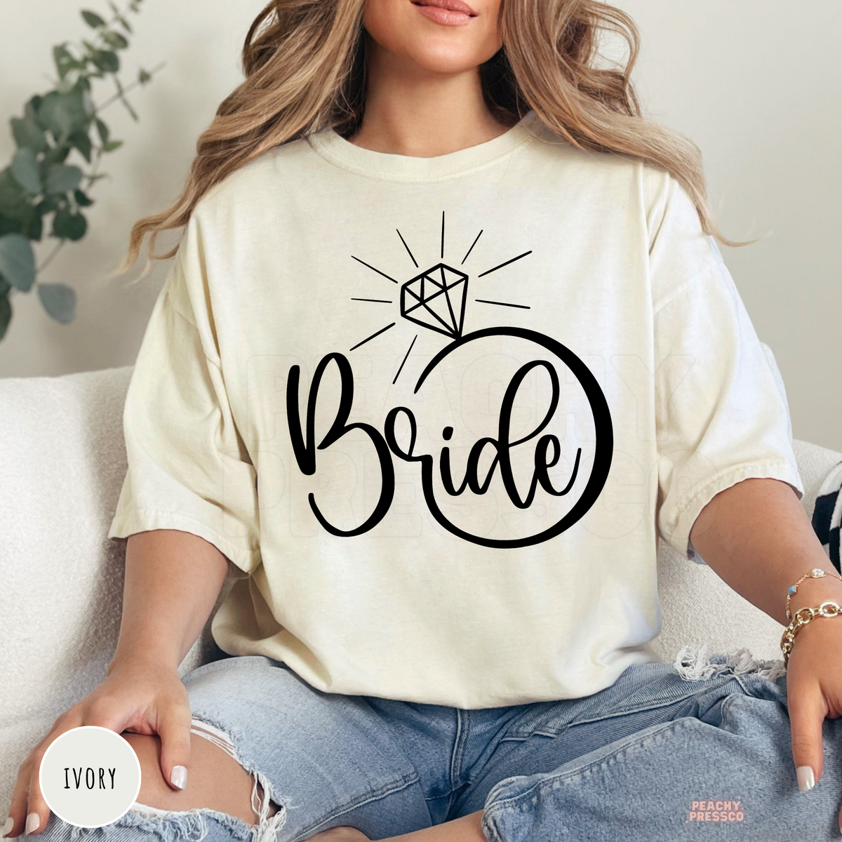 Ivory Comfort Colors t-shirt with a minimalist "Bride" engagement ring graphic in black, offering a timeless and elegant look for brides-to-be.