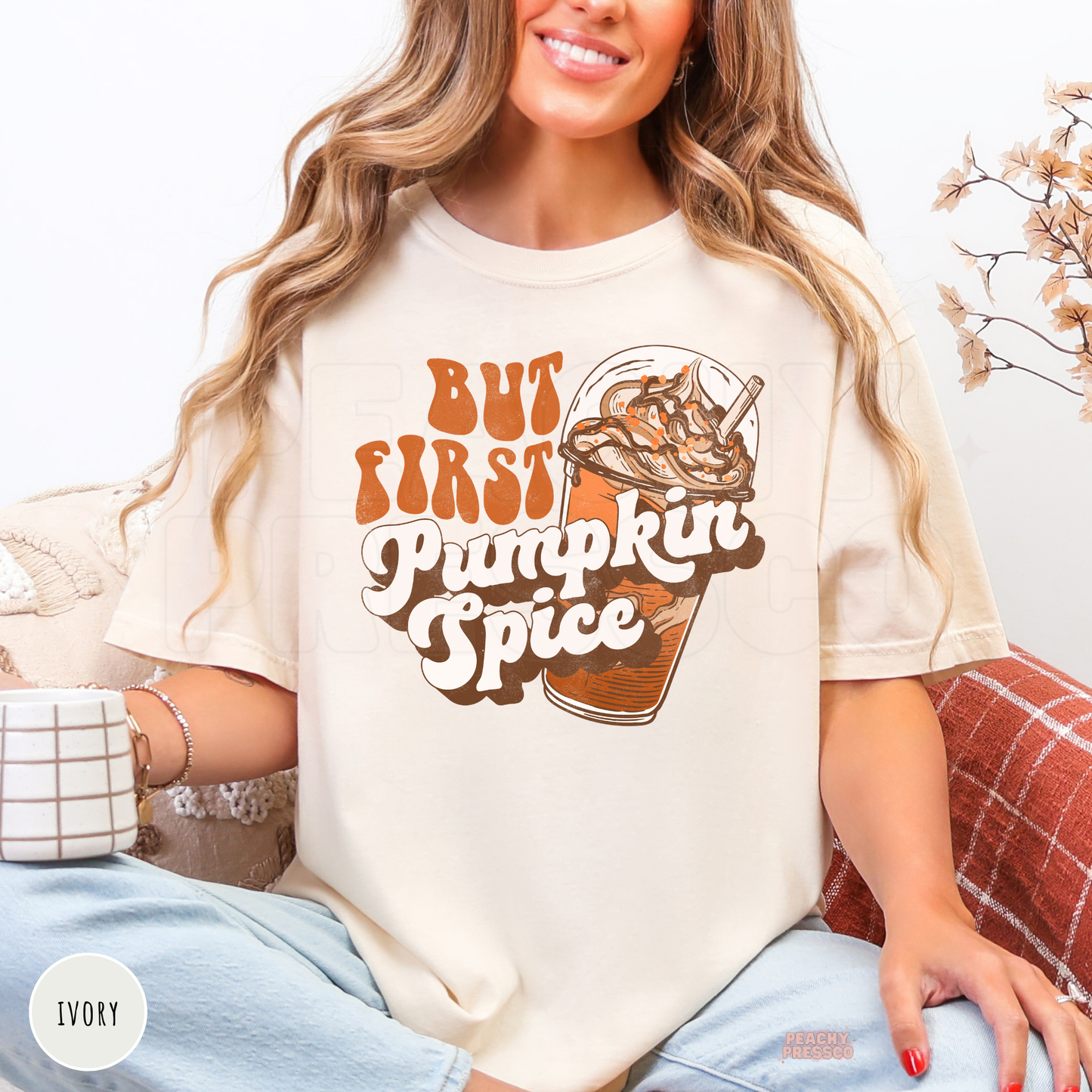 Woman wearing an ivory Comfort Colors t-shirt with a retro But First Pumpkin Spice graphic and iced coffee illustration for fall coffee lovers.
