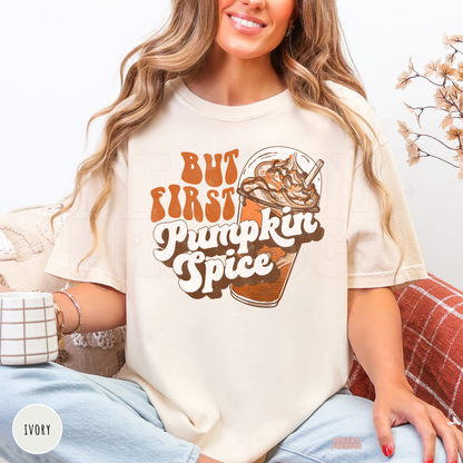 Woman wearing an ivory Comfort Colors t-shirt with a retro But First Pumpkin Spice graphic and iced coffee illustration for fall coffee lovers.