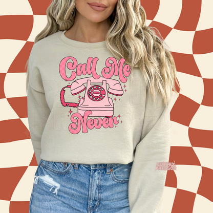 Retro Call Me Never pink rotary telephone graphic displayed on a sand-colored crewneck sweatshirt with playful coquette aesthetic.