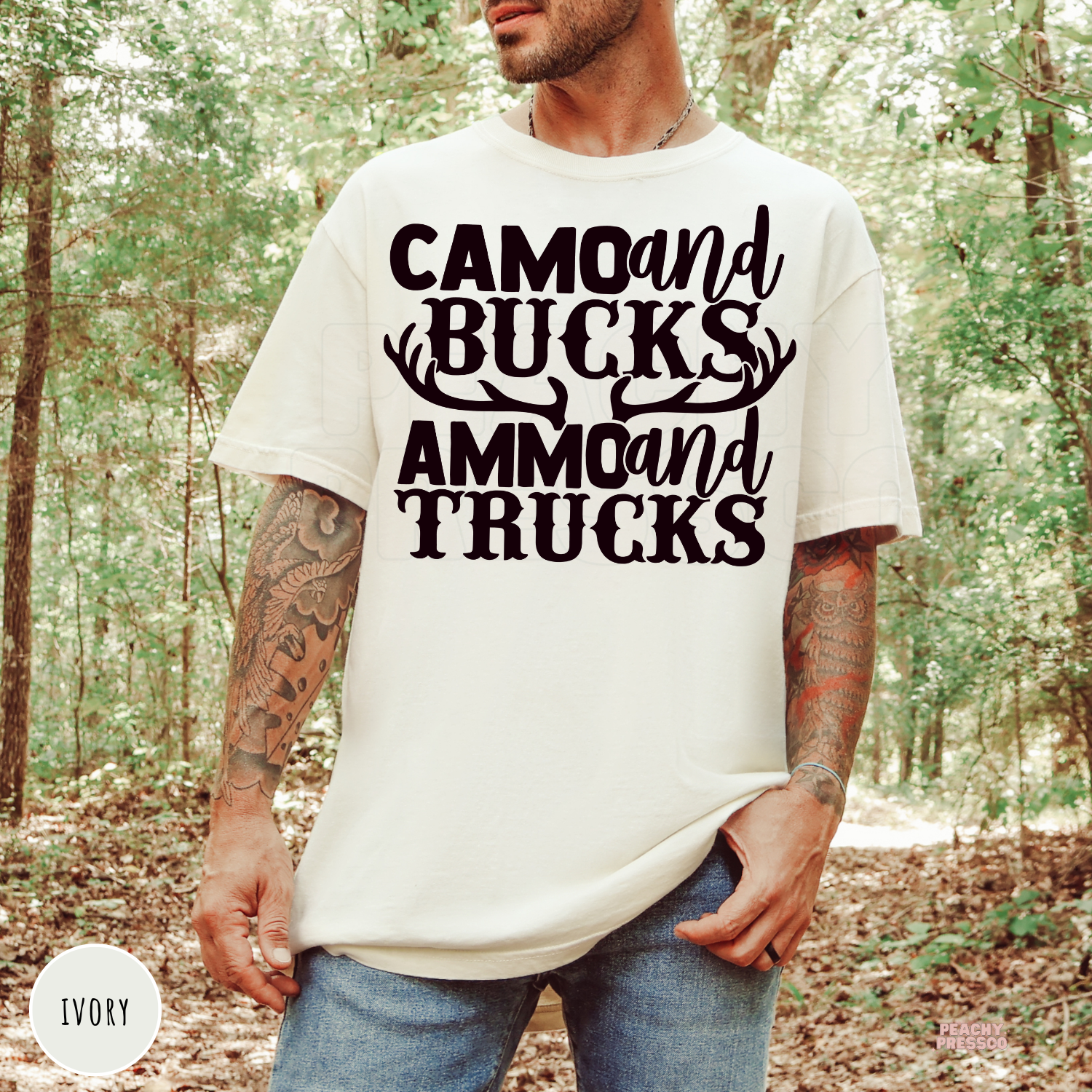 Ivory garment-dyed t-shirt featuring the bold "Camo and Bucks Ammo and Trucks" deer hunting design with antlers. Ideal gift for hunting dads, outdoorsmen, and truck lovers.