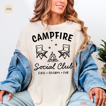 Ivory Campfire Social Club shirt featuring a cozy bonfire illustration, camping chairs and Fires Friends Fun design.