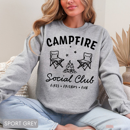 Sport grey Campfire Social Club sweatshirt featuring a campfire scene with camping chairs, stars and outdoor social club lettering.