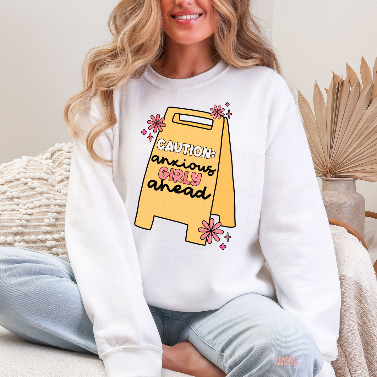White Caution Anxious Girly Ahead sweatshirt with a playful yellow warning sign, pink daisy flowers and funny overthinking girly quote.