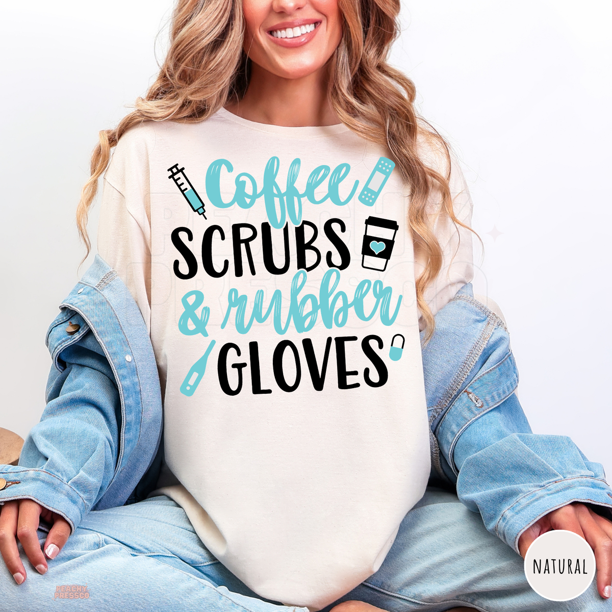 Woman wearing a natural shirt with Coffee Scrubs & Rubber Gloves graphic in turquoise and black, featuring medical icons.