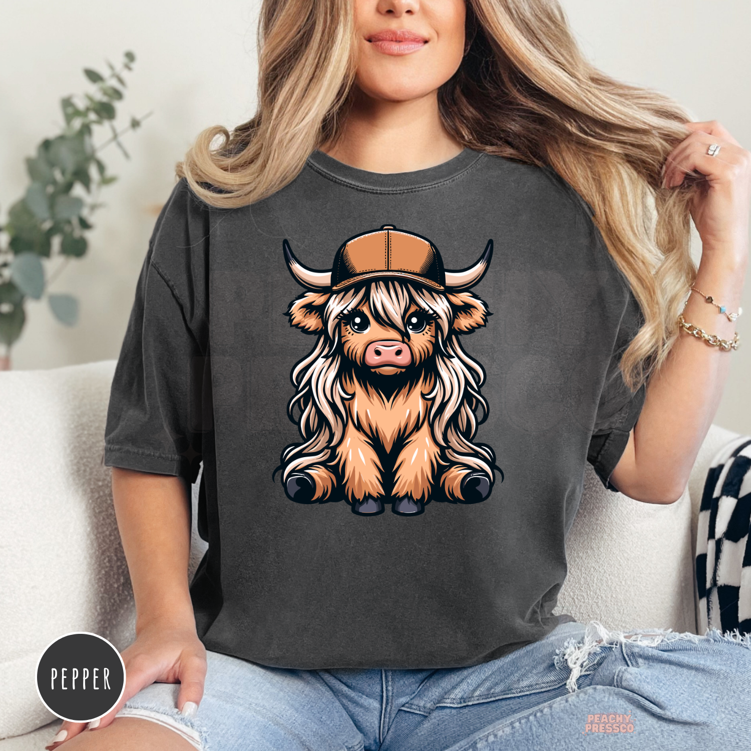 Pepper Comfort Colors t-shirt with a cute Highland cow wearing a trucker hat in a western country design.