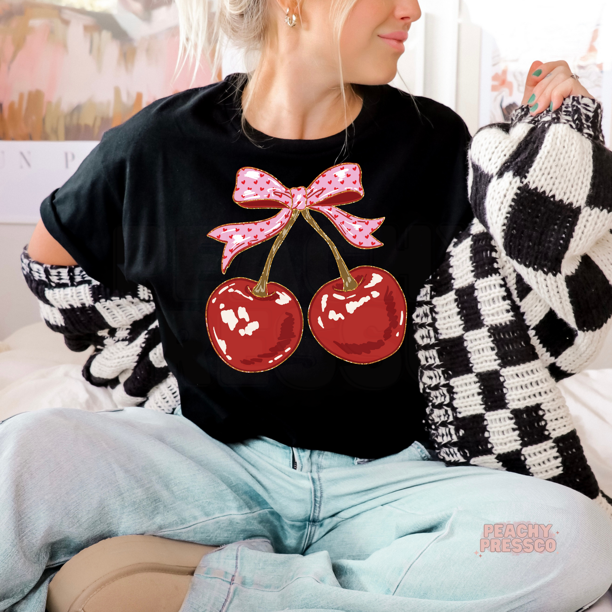 Black graphic t-shirt featuring red cherries with a pink coquette bow, cute cherry aesthetic shirt for women.