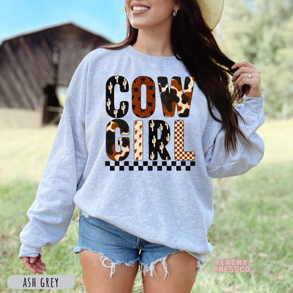Ash grey western sweatshirt with a colorful Cowgirl graphic in cow print, cactus, checkerboard, and rustic western patterns.