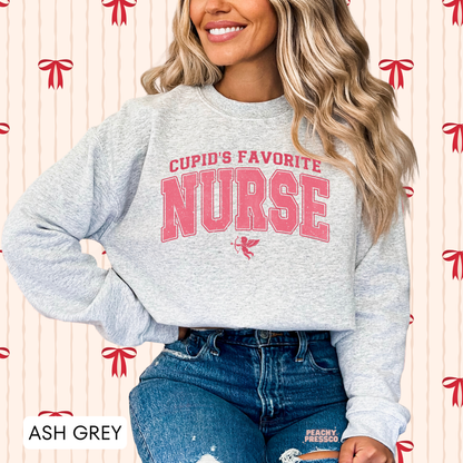 Ash grey sweatshirt displaying a distressed pink "Cupid's Favorite Nurse" graphic with Cupid, making a thoughtful Valentine's gift for nurses.