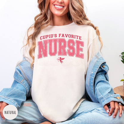 Natural shirt featuring a vintage pink "Cupid's Favorite Nurse" graphic with distressed varsity lettering and Cupid, perfect for Valentine's Day.