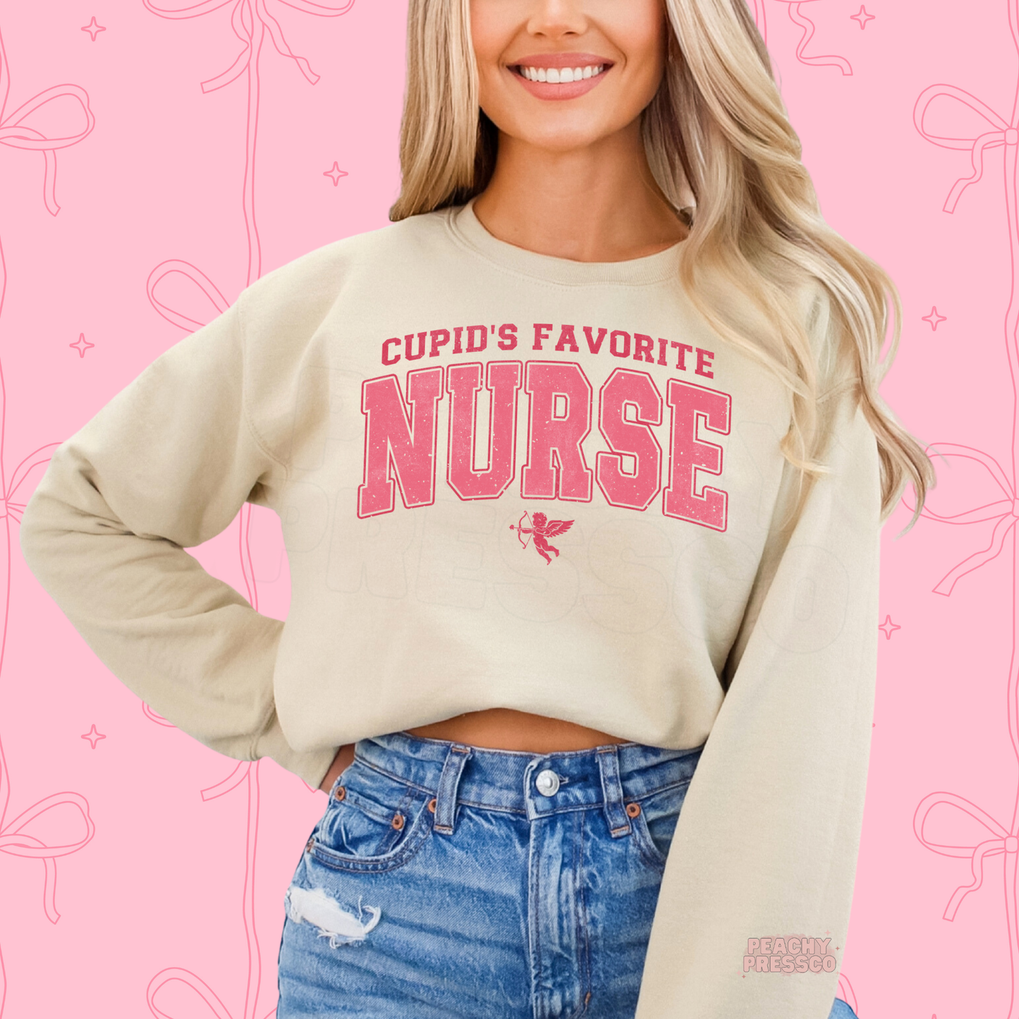 Sand sweatshirt featuring a vintage pink "Cupid's Favorite Nurse" design with varsity lettering and Cupid for a festive Valentine's look.