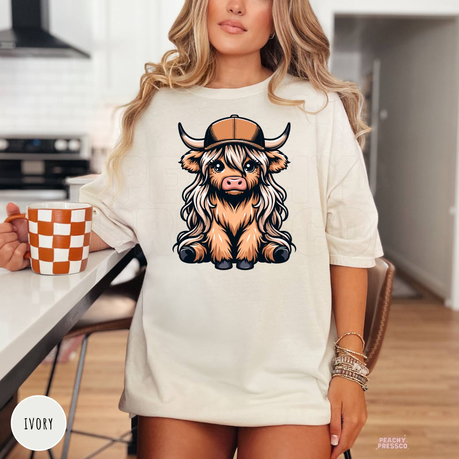 Ivory unisex t-shirt featuring a cute Highland cow wearing a trucker hat with a western-inspired graphic.