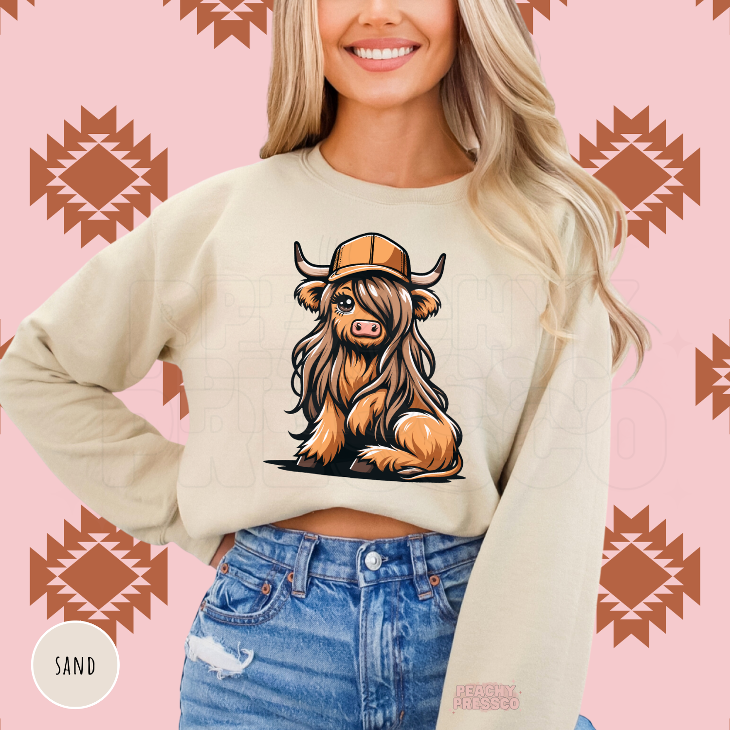 Cute Highland cow with long hair and a tan trucker hat on a sand colored western graphic sweatshirt.