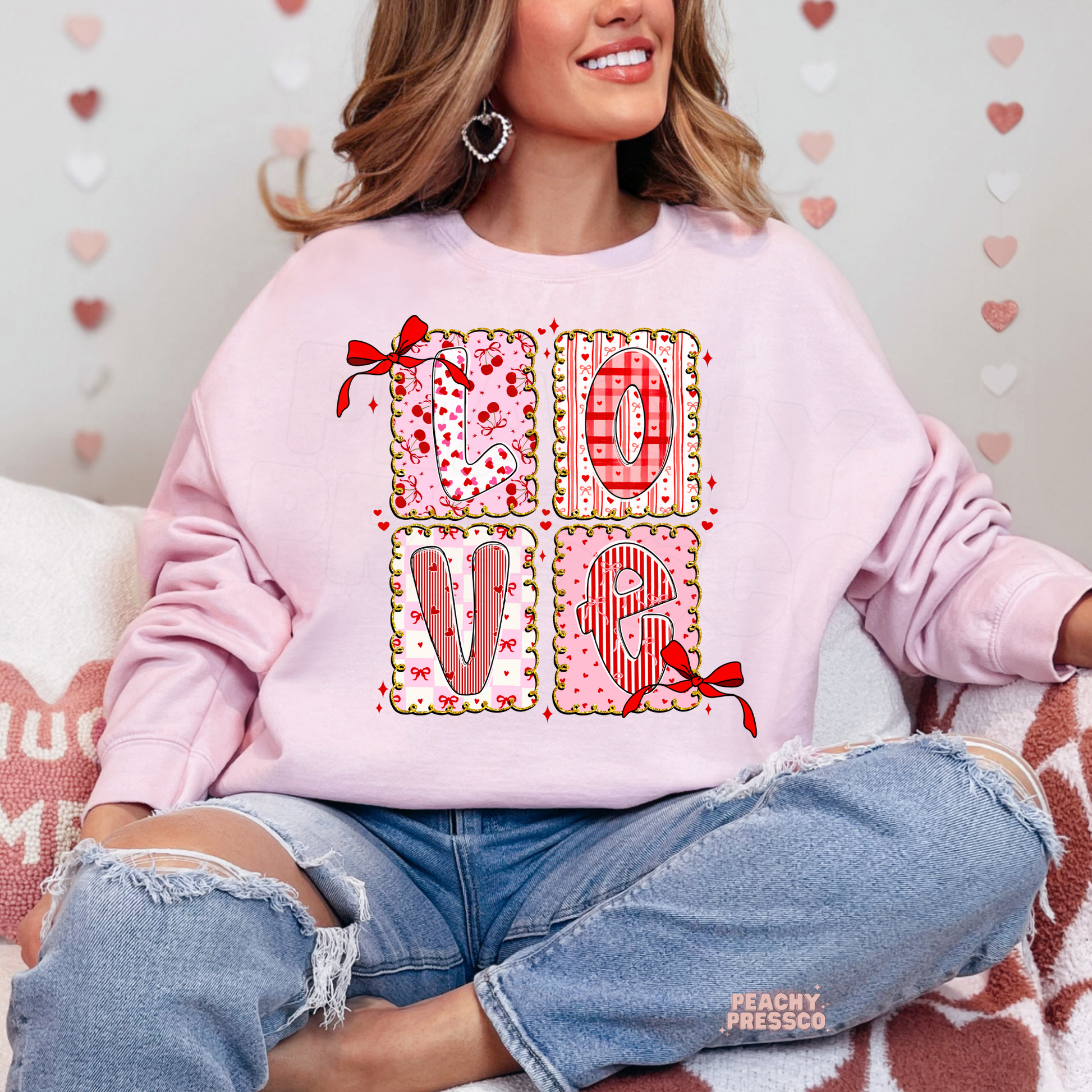 Light pink sweatshirt featuring a romantic LOVE patchwork design with decorative bows, heart patterns, and feminine coquette Valentine's artwork.