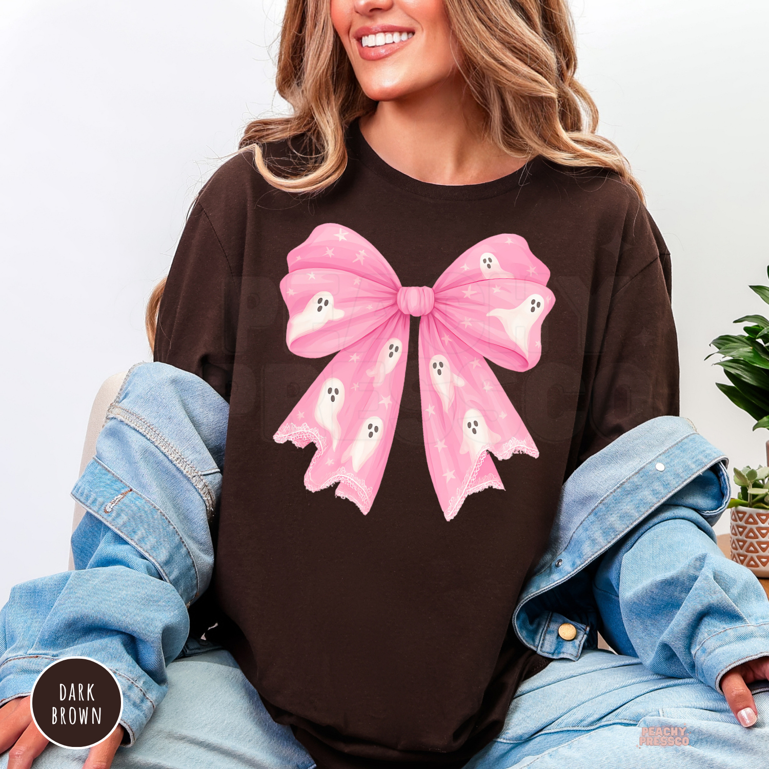 Dark brown Halloween T-shirt featuring a girly pink bow covered in cute white ghosts and whimsical stars