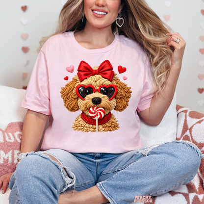 Light pink unisex t-shirt featuring an adorable Valentine's puppy graphic with a red bow, heart sunglasses, and a peppermint lollipop.