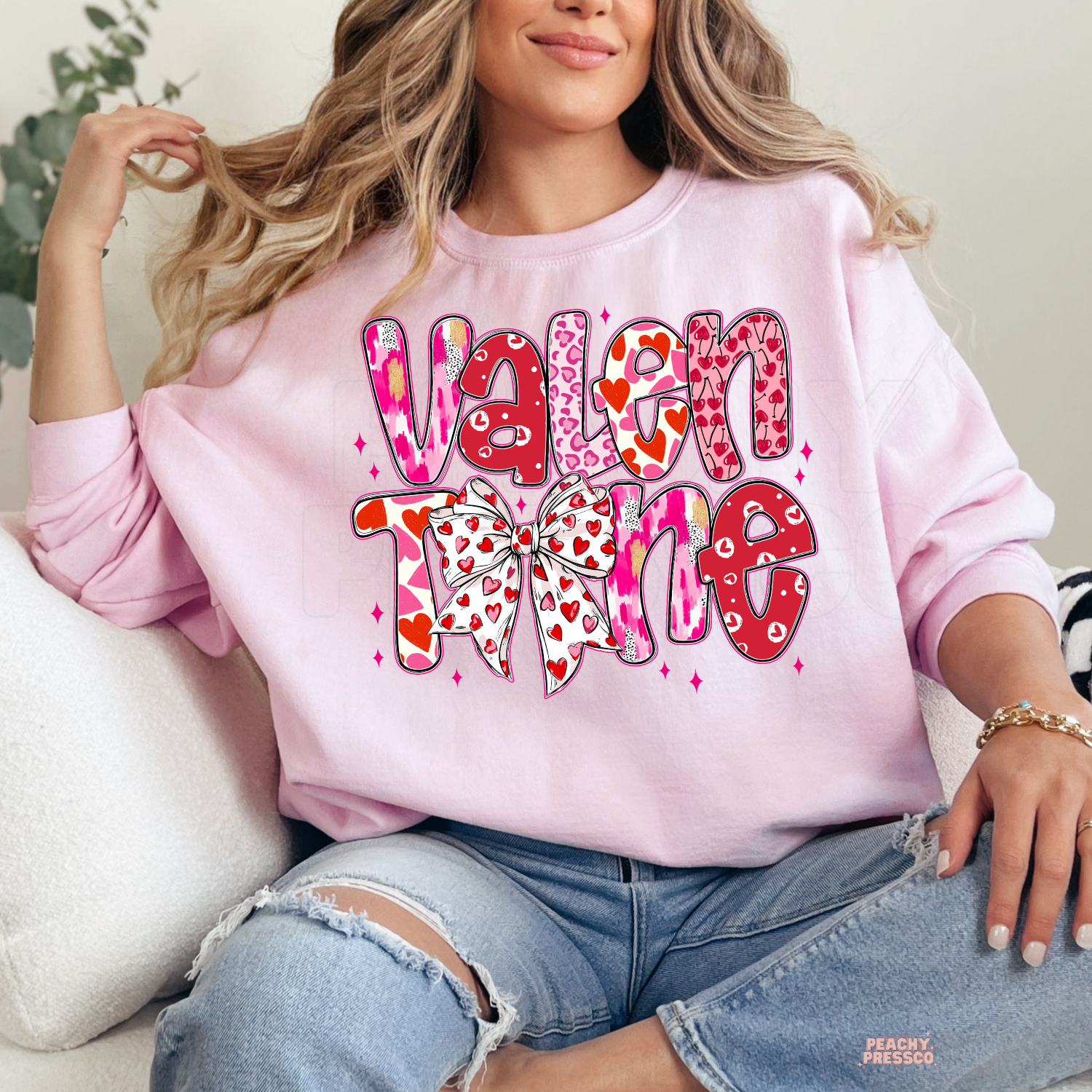 Soft pink unisex t-shirt with a retro stacked "Valentine" design featuring hearts and a cute coquette bow.

