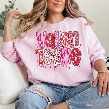 Soft pink unisex t-shirt with a retro stacked "Valentine" design featuring hearts and a cute coquette bow.
