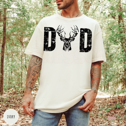 Ivory t-shirt featuring a vintage distressed "DAD" graphic with a majestic buck deer head. Great gift for hunting dads, outdoorsmen, and country lifestyle lovers.