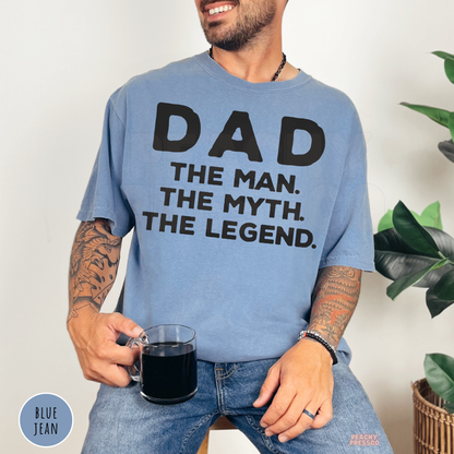 Photo of a man wearing a Blue Jean garment-dyed t-shirt with the "Dad The Man The Myth The Legend" graphic.