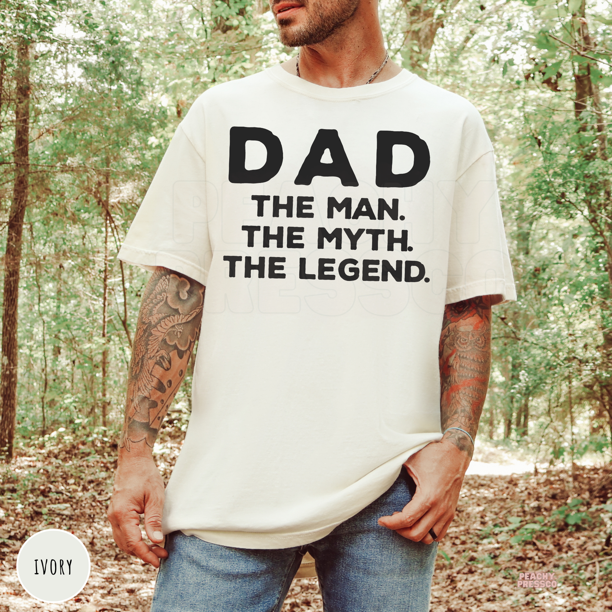 Man wearing an ivory t-shirt featuring the bold "Dad The Man The Myth The Legend" graphic, perfect for Father's Day celebrations.