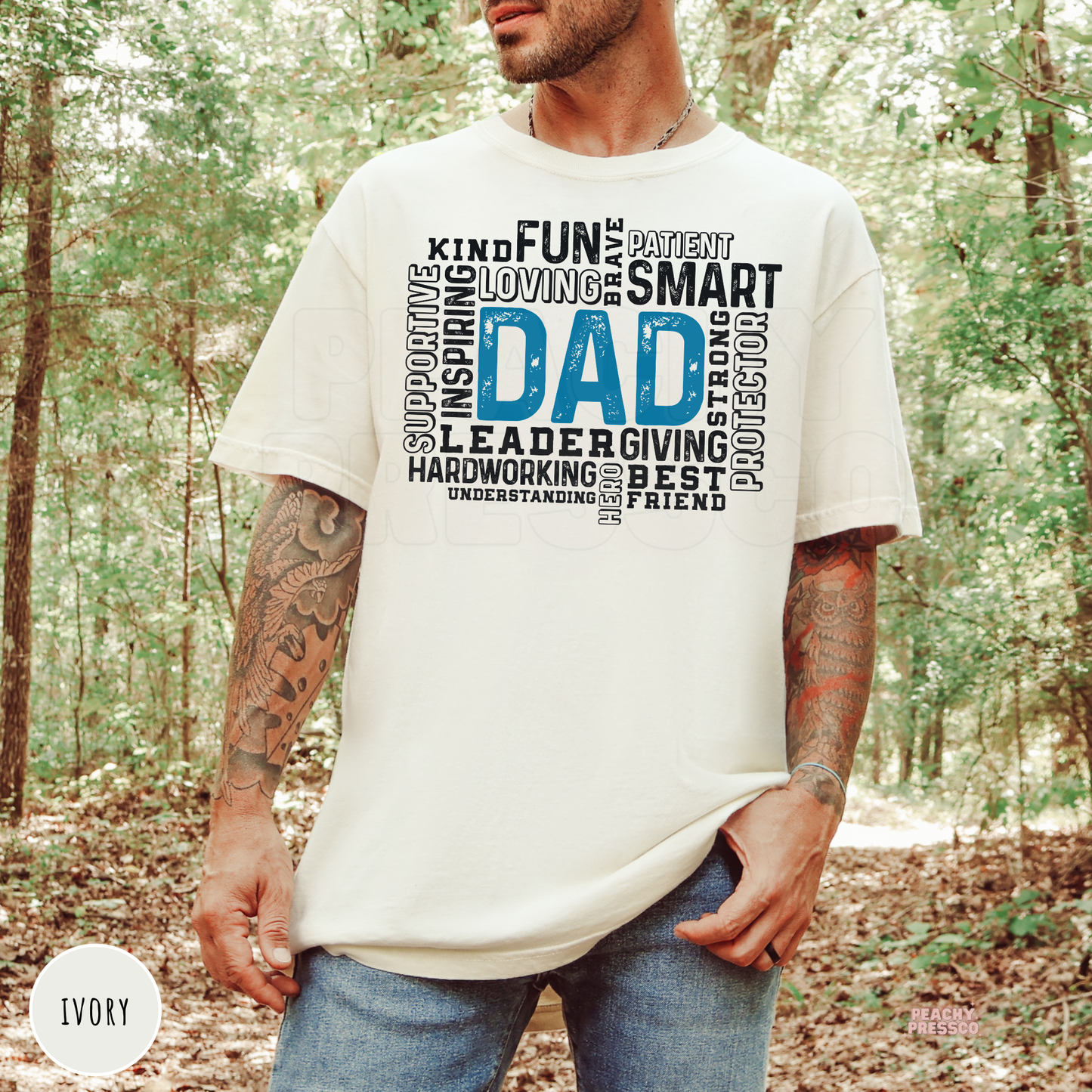 Ivory Comfort Colors style t-shirt with a blue "Dad" word cloud design highlighting qualities like kind, patient, strong, loving, protector, and best friend. Perfect gift for fathers.