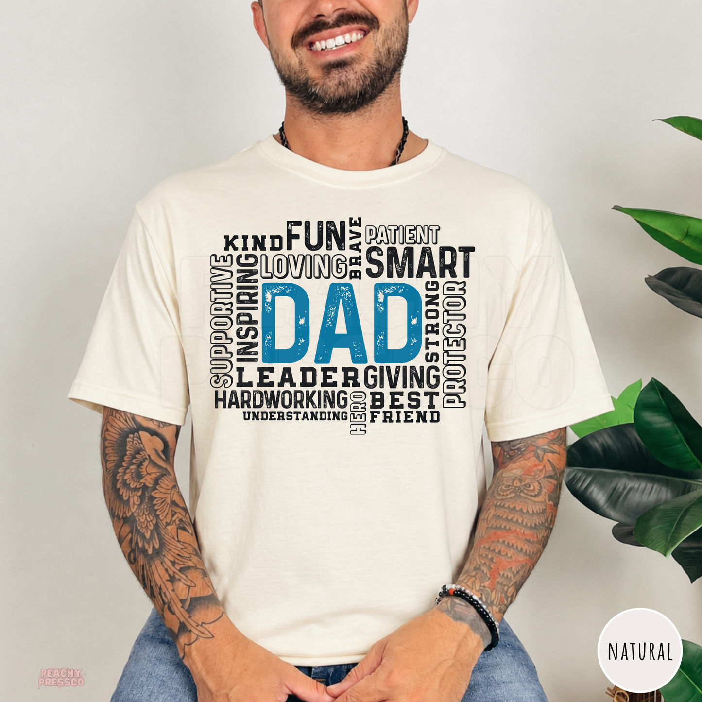 Natural unisex t-shirt featuring a blue "Dad" word art typography design with words describing a loving, supportive, hardworking father. Great Father's Day gift for dad.