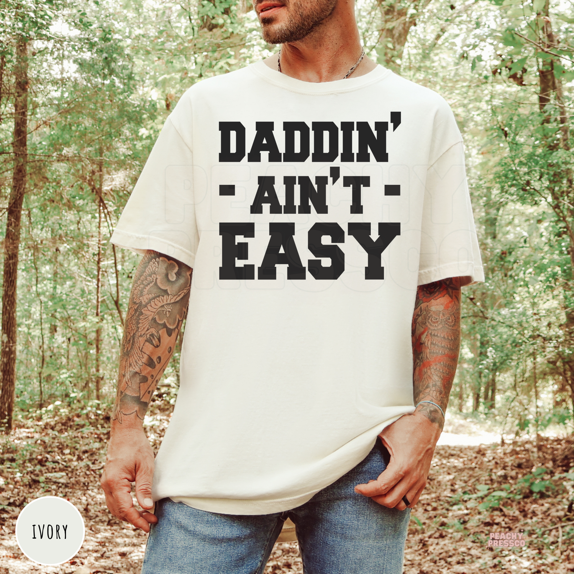 Man wearing an ivory t-shirt featuring the bold "Daddin' Ain't Easy" graphic, a funny Father's Day gift for dads.