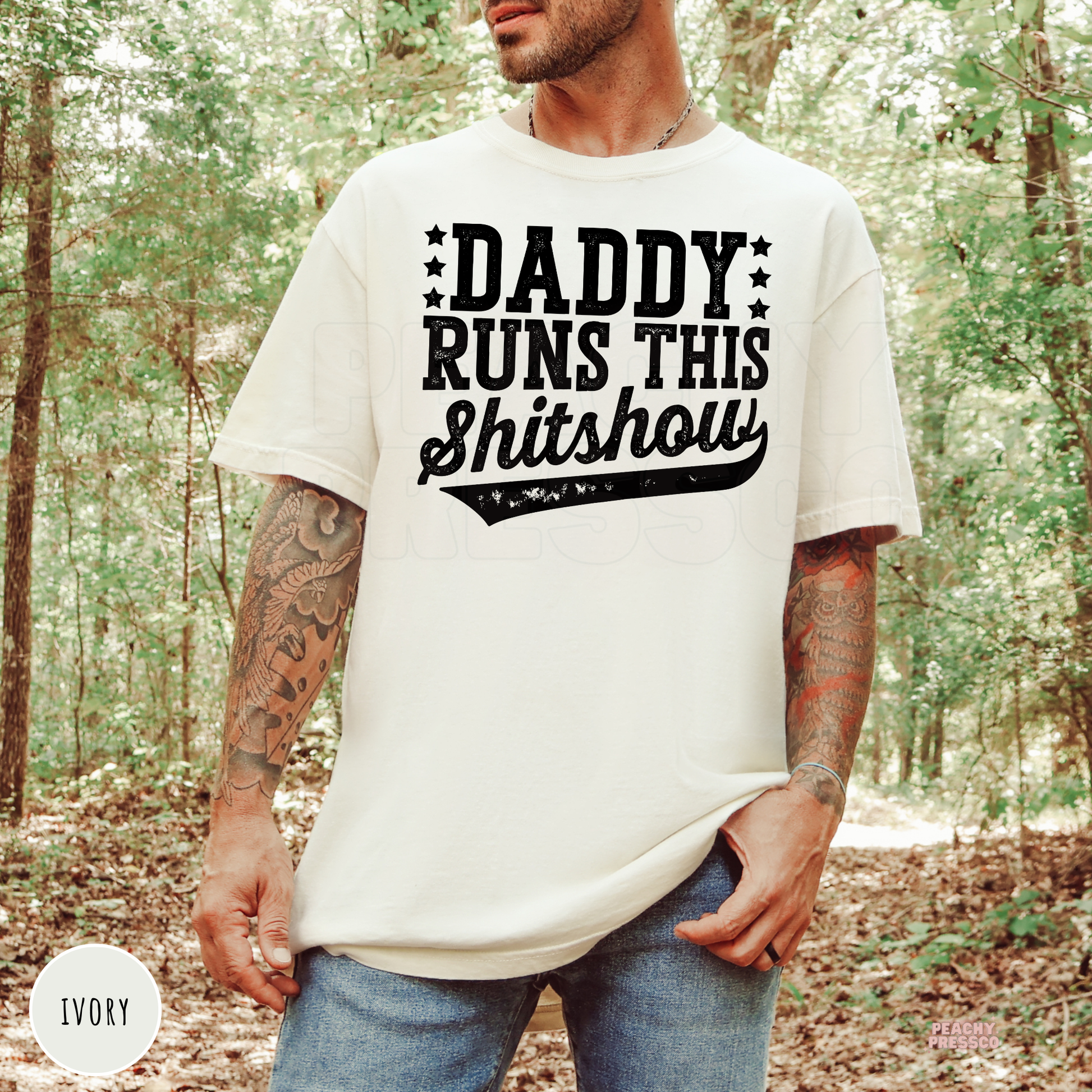 Ivory Comfort Colors t-shirt featuring the Daddy Runs This Shitshow distressed design in black lettering, a funny shirt for dads.
